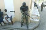 Oprørsstyrker patruljerer gaderne i Haitis næststørste by, Cap-Haitien, hvor rebellernes hurtige sejr blev efterfulgt af befolkningens plyndringer og lynchninger.   Foto: AP 