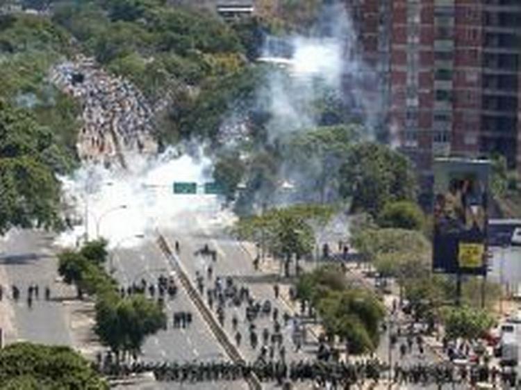 Demonstranter flygter fra tåregasgranaterne i Caracas. - Foto: AP 
