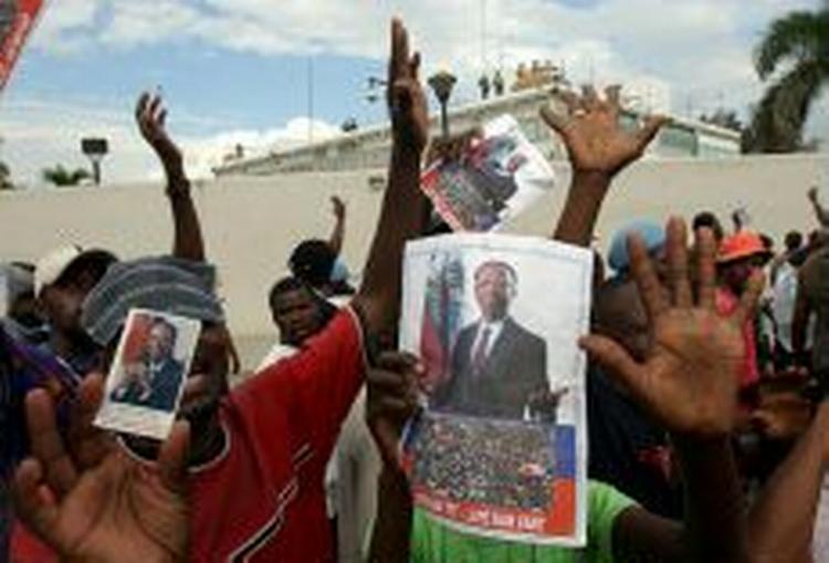 Aristide-tilhængere demonstrerer foran den amerikanske ambassade i hovedstaden Port-au-Prince. - Foto: AP 