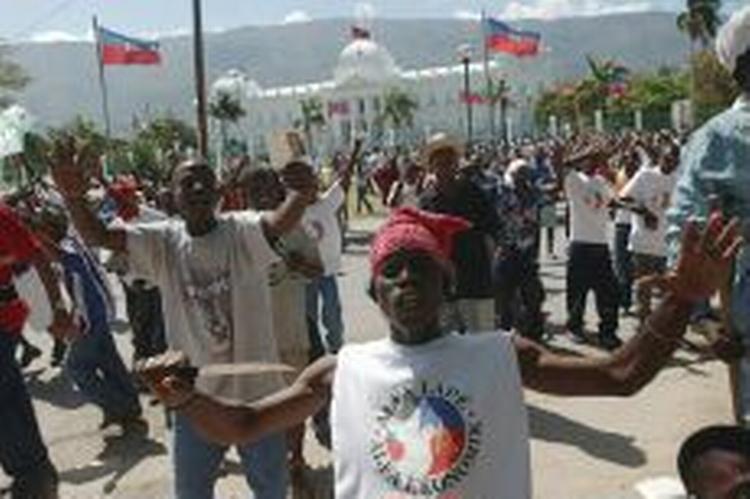 Hundredvis af haitianere forsamledes ved præsidentpaladset, da nyheden om Aristides flugt spredte sig. - Foto: AP 