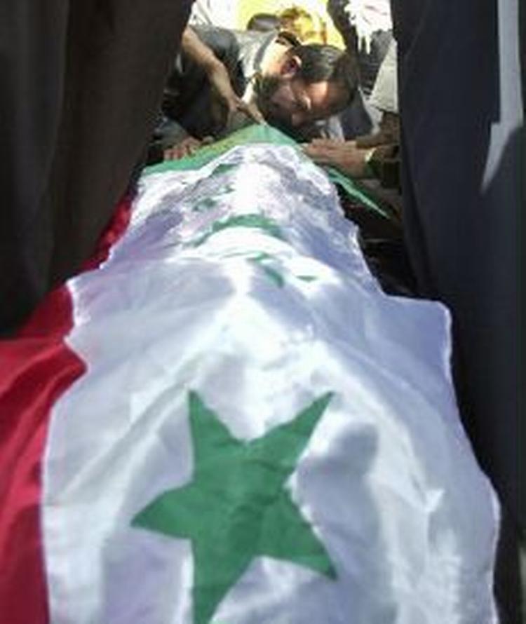 En pårørende sørger ved et offer indsvøbt i det irakiske flag efter terrorangrebne i Kerbala i Bagdad. - Foto: AP 