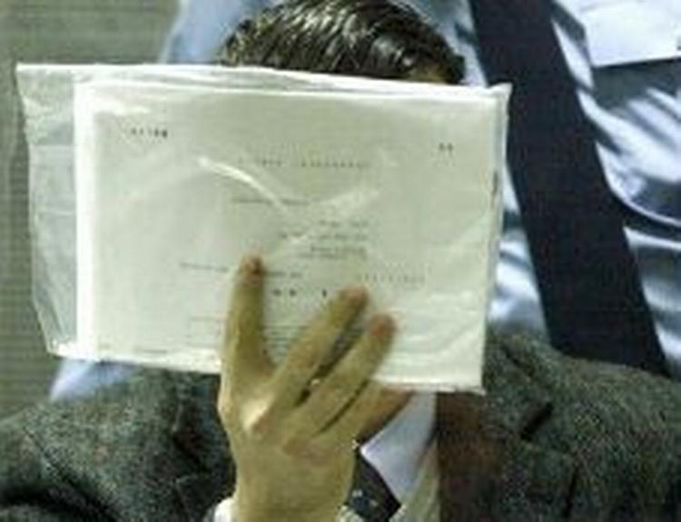 Marc Dutroux gemte sit ansigt bag papirer. - Foto: AP 