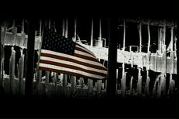 I to af de fire reklamer ser man bl.a. brandfolk, der bærer et lig svøbt i det amerikanske flag væk fra Ground Zero. - Foto: AP 