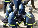 Redningsarbejdere er i gang med at bære et af ofrene fra et af de eksploderede tog i Madrid. - Foto: AP 