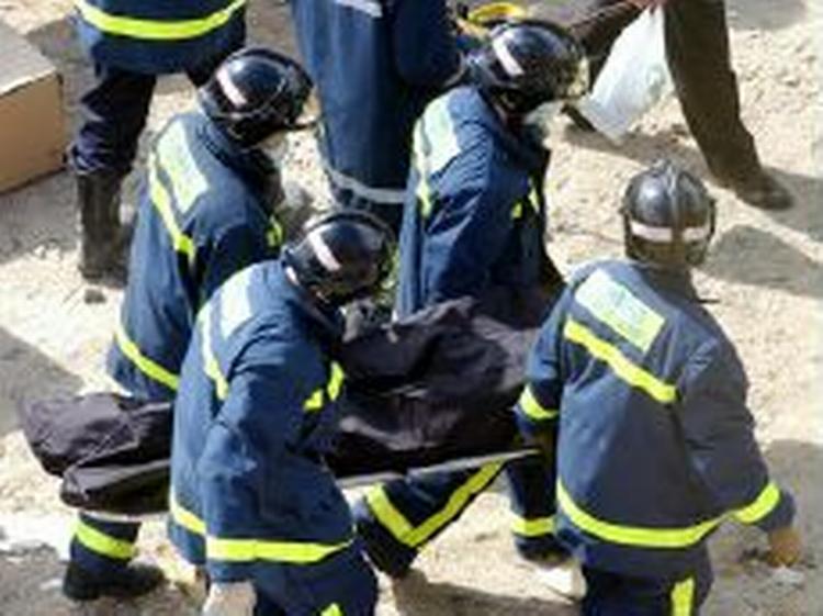 Redningsarbejdere er i gang med at bære et af ofrene fra et af de eksploderede tog i Madrid. - Foto: AP 