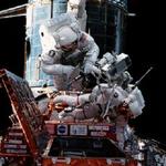 To astronauter reparerer på Hubble rum-teleskopet ude i rummet. Nu vil astronauterne kæmpe for Hubbles liv. - Arkivfoto: Spacephotos.com 
