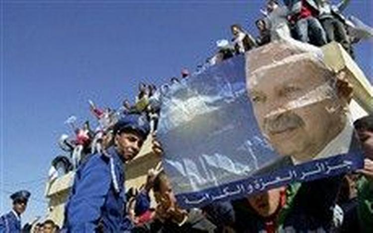 Tilhængere af den regerende præsident, Abdelaziz Bouteflika, vifter med hans plakat på et valgmøde for modkandidaten Ali Benflis. De to var tidligere venner, nu er de bitre politiske fjender. Bouteflika er storfavorit til at vinde 