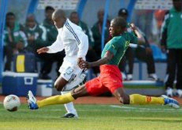 Cameroun-backen Orjinta (grøn) i aktion i den kontroversielle spilledragt. - Foto: AP 
