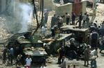 Irakere plyndrer amerikanske Humvee-jeeps, der blev ramt af en eksplosion tidligere på dagen. - Foto: AP 