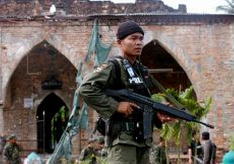 En thailandsk politimand bevogter en moske i Pattani-provinsen i den sydlige del af landet. 32 militante oprørere mistede livet, da sikkerhedsstyrker stormede moskeen. - Foto: AP 