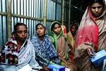 Ved et møde med Grameen Bank har Nurelli Begum (til venstre) netop modtaget en splinterny Nokia 3315. Hun er nu en af 50.000 kvinder i Bangladesh, der fungerer som sin landsbys telefondame.   Foto: Michael Lund 