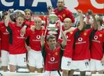 Anfører Roy Keane i midten med pokalen. - Foto: AP 
