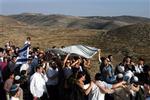 For bosætterne er det en festdag, da en ny Tora, jødernes hellige bog, bliver bragt til containersynagogen i en ulovlig bosætterudpost på Vestbredden.   Foto: Seri Ahikam 
