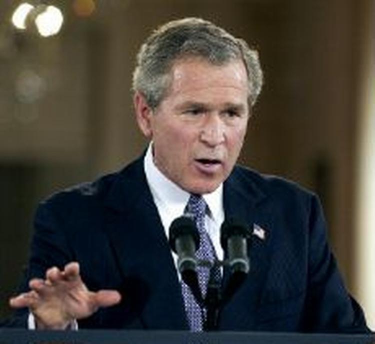George W. Bush holder af at vise Saddams pistol frem. Men den er ikke ladt, forsikrer han. - Foto: AP 