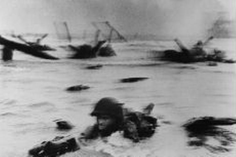 Den første angrebsbølge med amerikanske soldater rammer kysten. - Foto: Robert Capa 