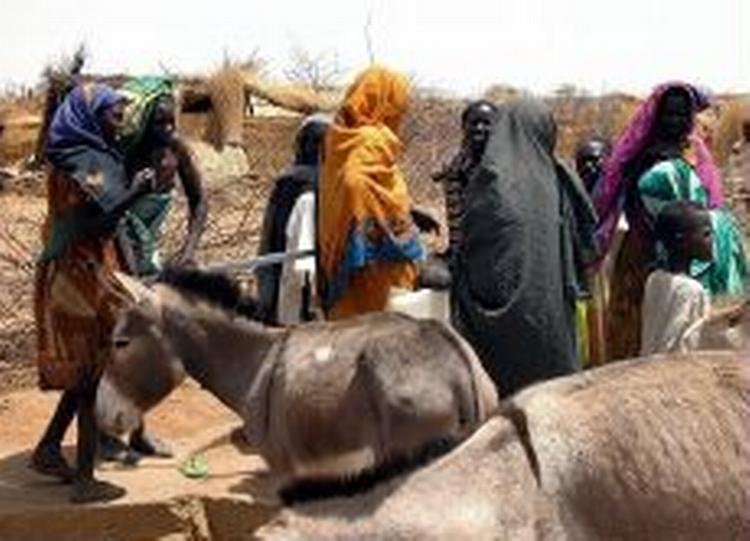 Kvinder pumper vand fra en brønd i en midlertidig flygtningelejr i Sudan. - Foto: AP 
