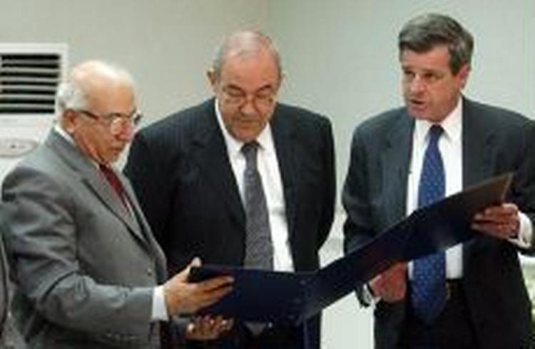 Iraks premierminister, lyad Allawi (midt) og Iraks justitsminister Midhat al-Mahmoudi (tv) modtager de officielle magtoverdragelses-papirer fra USA's forhenværende Irak-administrator, Paul Bremer. - foto: AP 