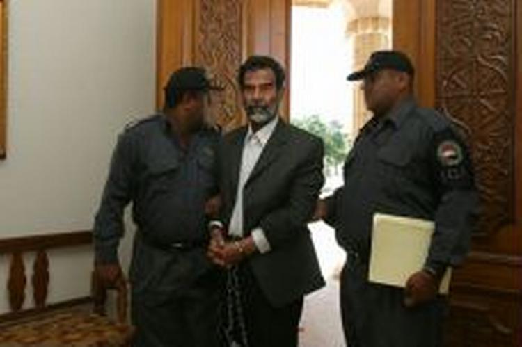 De fleste arabiske aviser hilser retssagen mod Saddam Hussein, der her ses blive ført ind i retten i går, velkommen. - Foto: AP 
