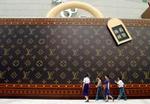 Louis Vuitton er også for middelklassen. Her en gigantisk reklame for tasken i Shanghai i Kina. - Foto: AP 