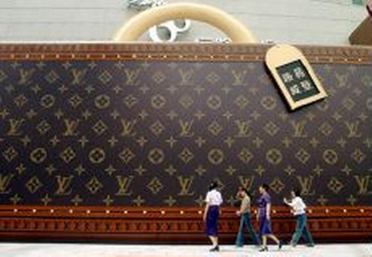 Louis Vuitton er også for middelklassen. Her en gigantisk reklame for tasken i Shanghai i Kina. - Foto: AP 