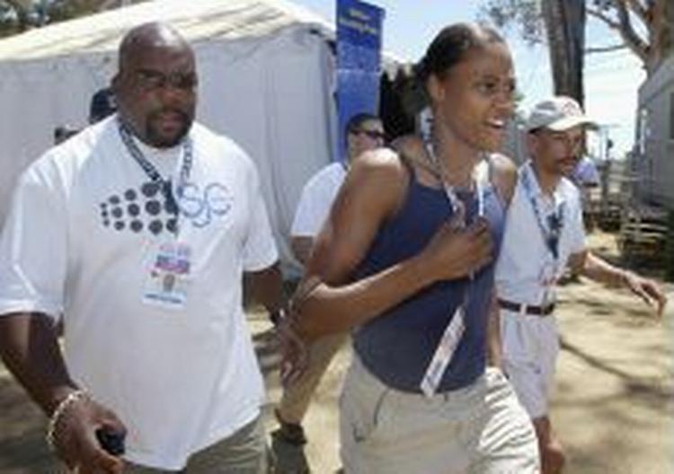 Marion Jones forlader en pressekonference efter at have annonceret, at hun opgiver satsningen på løb frem til OL i Athen. - Foto: AP 