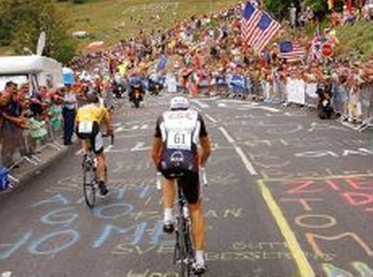 Armstrong startede to minutter efter Basso på enkeltstarten, men overhaler her CSC's italienske håb. - Foto: AP 