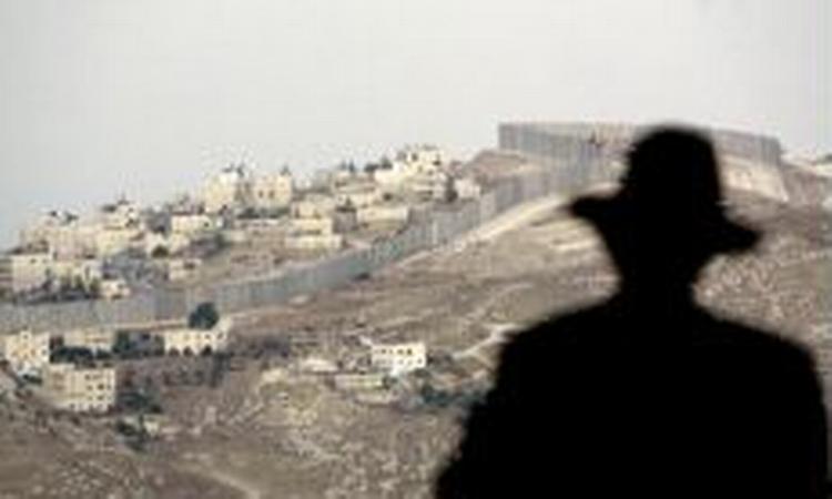 Billede af den omstridte barriere fra udkanten af Jerusalem. I forgrunden en ultraordodoks jøde. - Foto: AP 