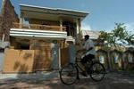 En cyklist passerer det hus, al-Qaeda-terroristen Ghailani boede sammen med sin usbekiske hustru. - Foto: AP 
