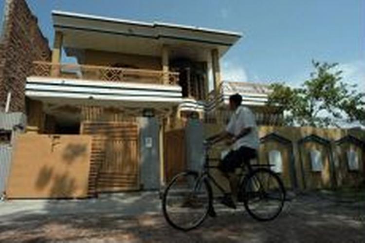 En cyklist passerer det hus, al-Qaeda-terroristen Ghailani boede sammen med sin usbekiske hustru. - Foto: AP 