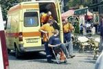 I første omgang forlød det, at angrebet var udløst af en håndgranat, men der var tale om en bombe gemt under en bil. Her hjælpes en af de sårede ind i en ambulance. - Foto: AP 