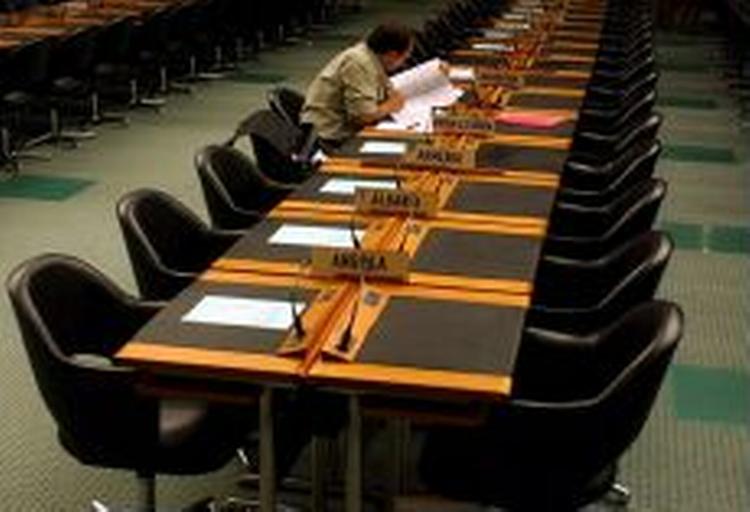 En WTO-delegeret har hele bordet for sig selv, kort før den afsluttende forhandlingsrunde begyndte i aftes. - Foto: AP 