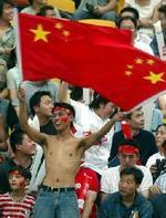 De fleste kinesíske fans fokuserer på fodbolden, men enkelte blander politik ind i billedet. - Foto: AP 