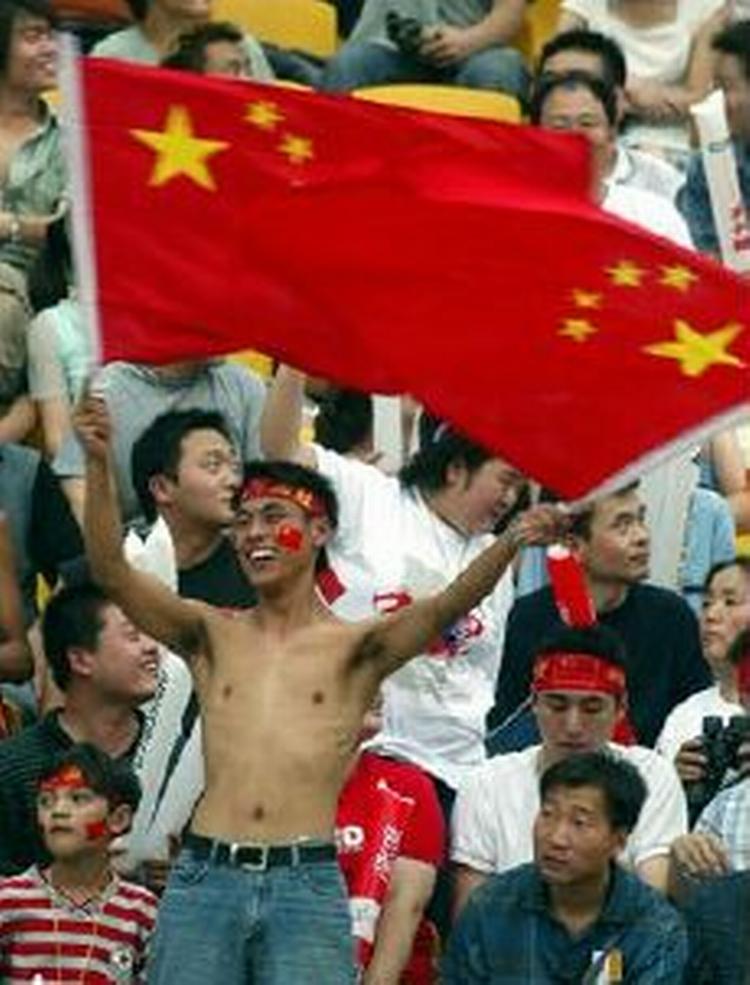 De fleste kinesíske fans fokuserer på fodbolden, men enkelte blander politik ind i billedet. - Foto: AP 