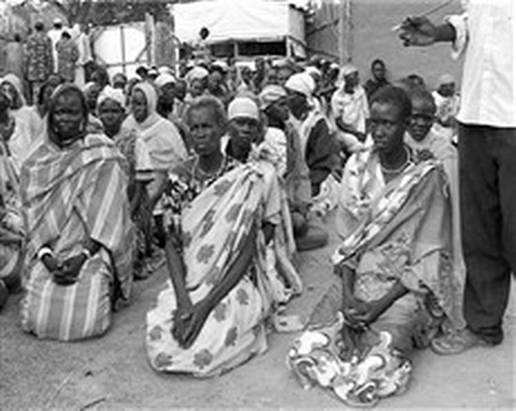 Flygtningekvinder fra Darfur-provinsen i Sudan venter tålmodigt på de sparsomme nødhjælpsrationer.   Foto: Runo Samuelsson 
