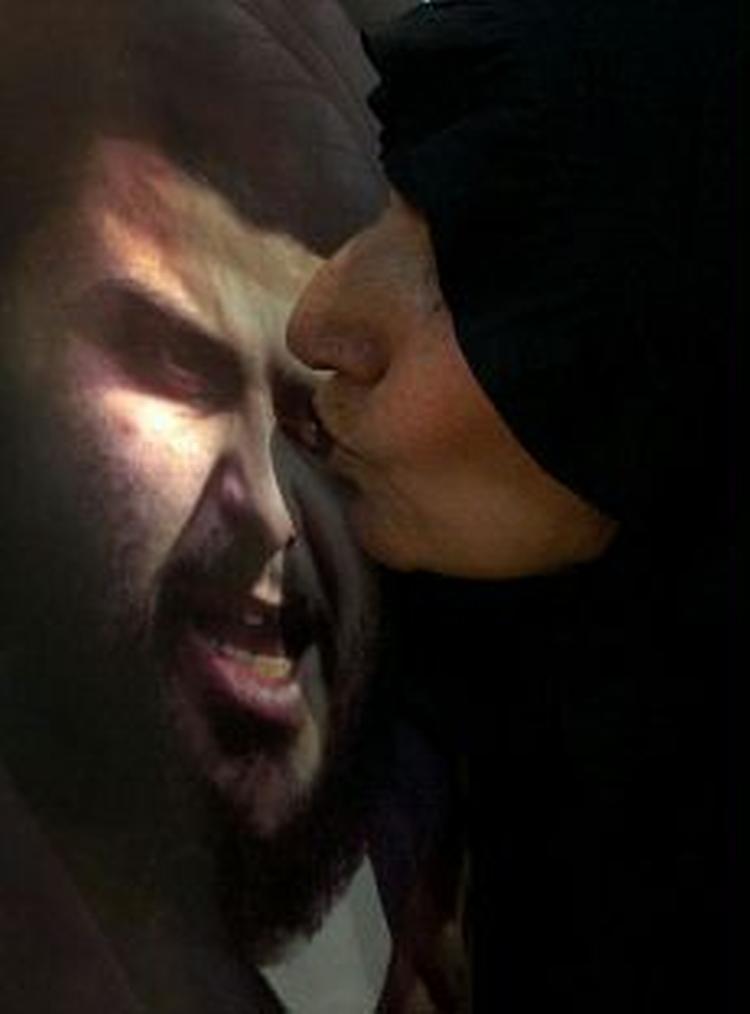 En shiamuslimsk kvinde kysser en plakat med den oprørske præst. - Foto: AP 
