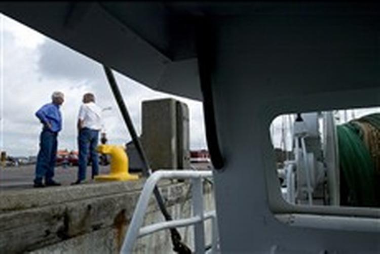 Esbjerg-fiskernes formand, Hans Aa (i hvid skjorte), på havnen, hvor fiskeriets krise ses i det ringe antal kuttere. I gamle dage lå kutterne side om side, men i dag fisker blot 70 kuttere fra Esbjerg.   Foto: Lars Skaaning 