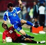 Grækernes Giorgos Karagounis slår for bolden, men bliver i denne situation den lille i opgøret med Albaniens Klodian Duro under VM-kvalifikationskampen i Tirana. - Foto: AP 