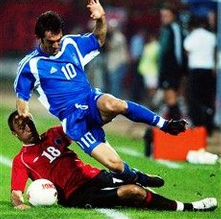 Grækernes Giorgos Karagounis slår for bolden, men bliver i denne situation den lille i opgøret med Albaniens Klodian Duro under VM-kvalifikationskampen i Tirana. - Foto: AP 