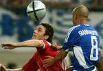 Fatih Tekke fra Tyrkiet i rødt kæmper om bolden mod græske Stylianos Giannakopoulos. - Foto: AP 