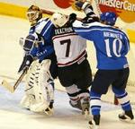 Nieminen forsøger at fjerne USA's Tkachuk (hvid) fra målmand Kiprusoffs åsyn. - Foto: AP 