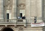 Fra en af balkonerne har den falske Batman spredt et banner ud, hvor der står 'Super dads of Fathers 4 Justice', mens han råber slagord. - Foto: AP 