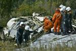 Russiske redningsfolk inspicerer det ene af de to passagerfly, der blev sprængt i luften kort efter starten fra lufthavnen i Moskva. - Arkivfoto: AP 