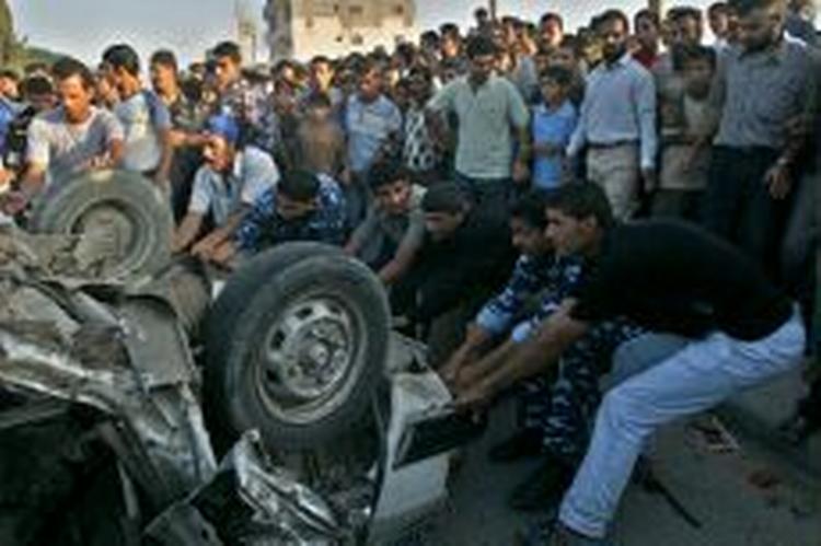 Mange palæstinensere stimler sammen omkring den bil, der blev ramt af et israelsk missil i den sydlige del af Gazastriben. - Foto: AP 