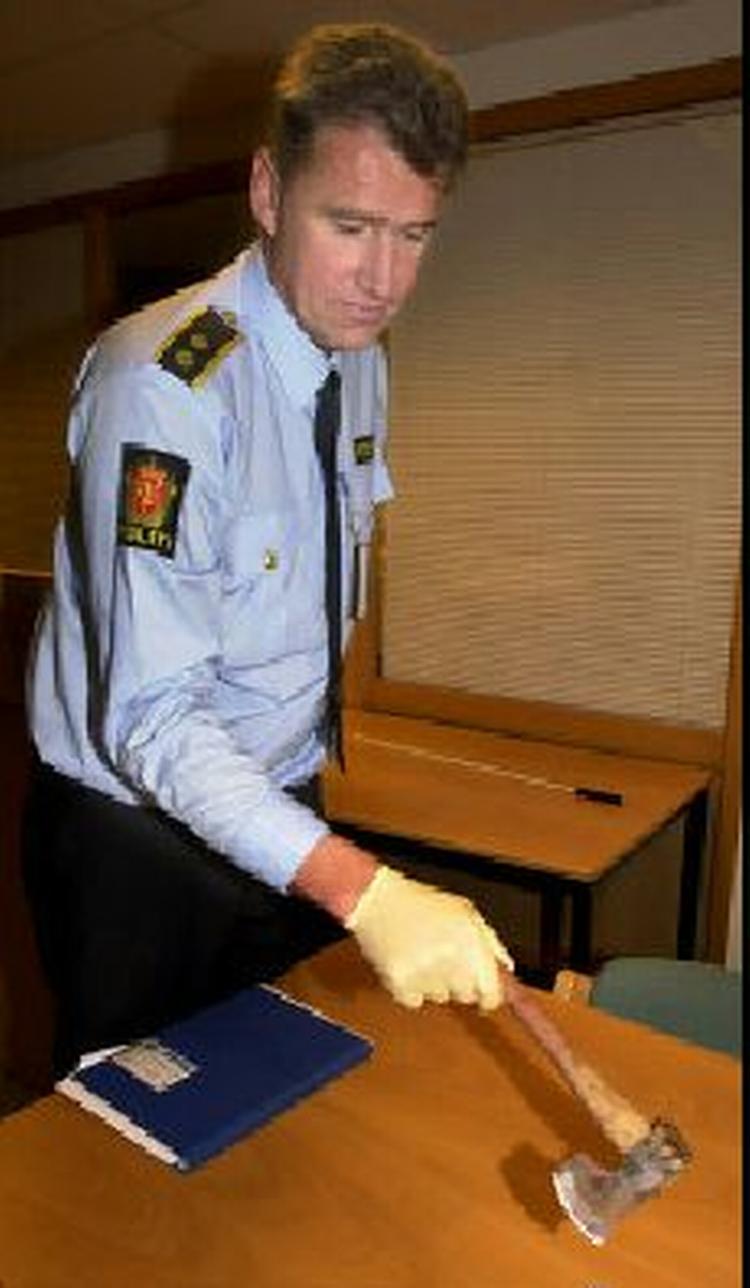En norsk betjent fremviser den økse som blev brugt ved angrebet i flyet. - Foto: AP 