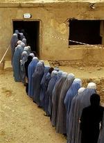 Afghanske kvinder i burkaer står i kø for at stemme i Kabul lørdag. Det første demokratiske præsidentvalg i landet forløb uden blodsudgydelser.   Foto: AP/Emilio Morenatti 