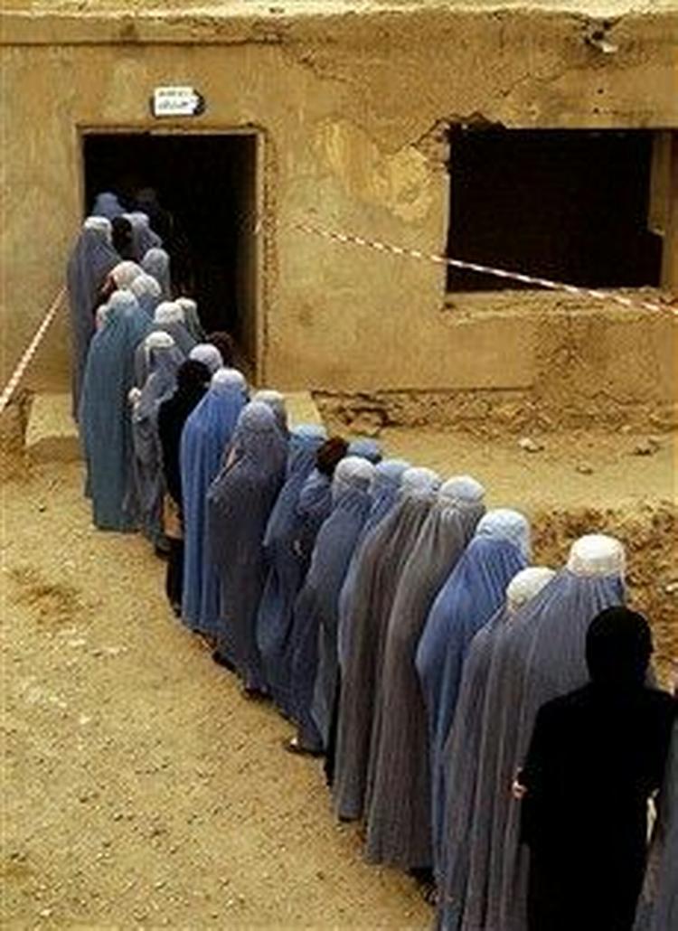 Afghanske kvinder i burkaer står i kø for at stemme i Kabul lørdag. Det første demokratiske præsidentvalg i landet forløb uden blodsudgydelser.   Foto: AP/Emilio Morenatti 