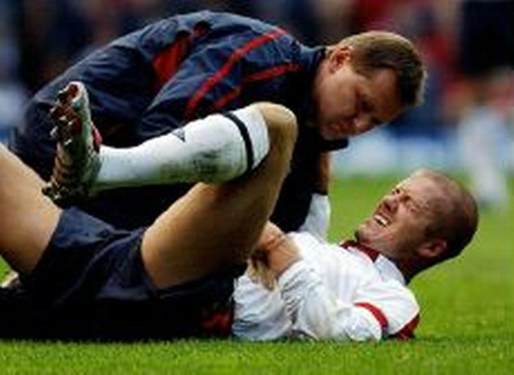 Beckham som han så ud dan han brækkede et ribben. Kort efter rejste han sig og flæskede en modstander for at få et gult kort. - Foto: AP 