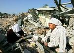 Palæstinensiske kvinder sidder i ruinerne af deres huse i byen Beit Lahiya i Gaza, efter at israelske tanks torsdag morgen trak sig ud af byen. I dag fordømte Storbritanniens udenrigsminister, Jack Straw, israelernes offensiv i Gaza. - Foto:A 