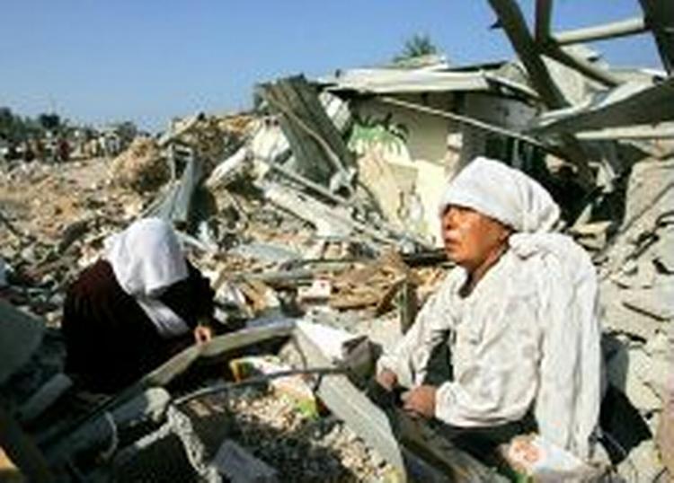Palæstinensiske kvinder sidder i ruinerne af deres huse i byen Beit Lahiya i Gaza, efter at israelske tanks torsdag morgen trak sig ud af byen. I dag fordømte Storbritanniens udenrigsminister, Jack Straw, israelernes offensiv i Gaza. - Foto:A 