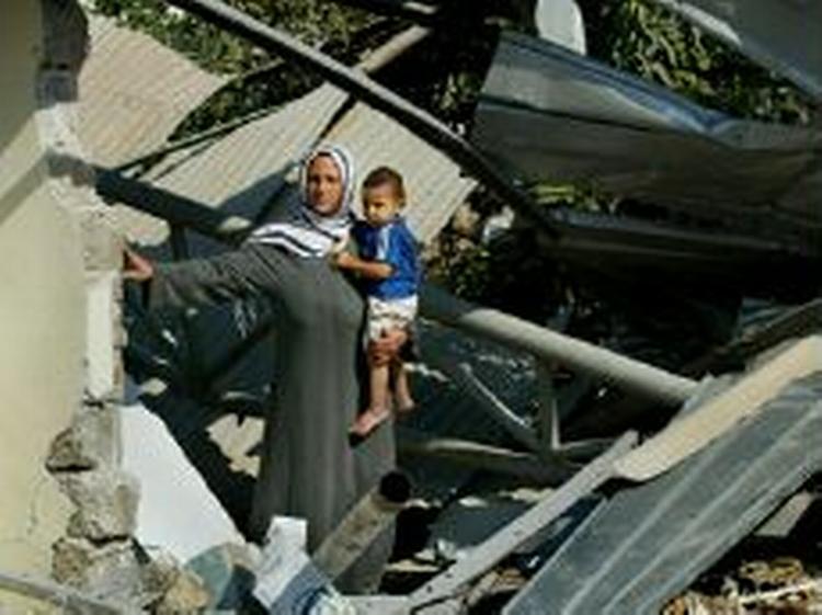 En palæstinensisk kvinde står mellem resterne af et hus, som blev ødelagt af israelske styrker i Beit Lahiya. - Foto: AP 